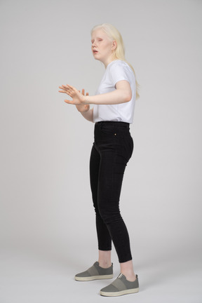 Three-quarter view of a young girl reaching her arms out