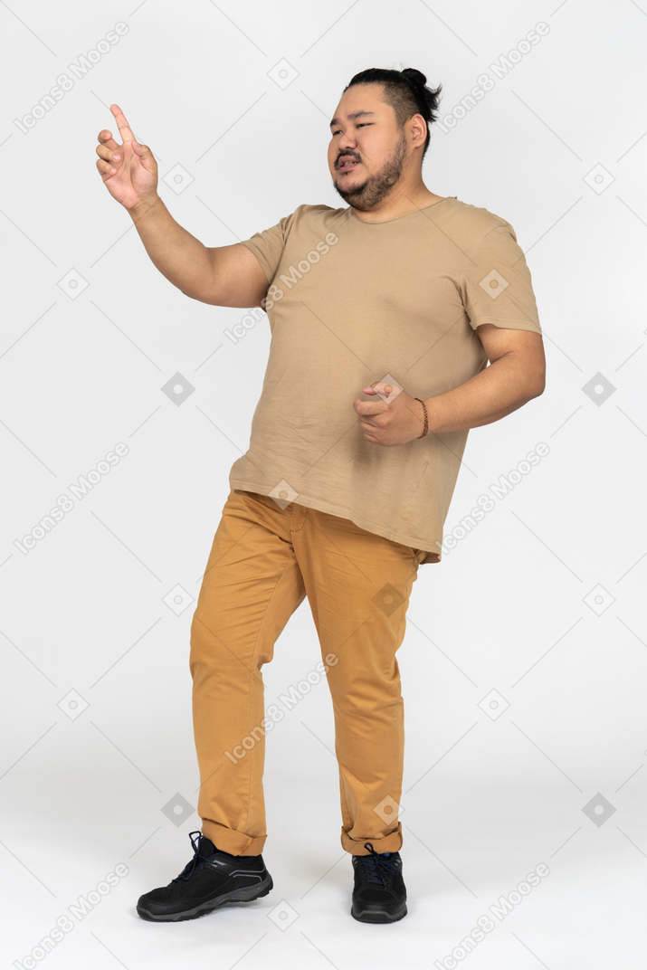 Serious asian man pointing aside with a finger