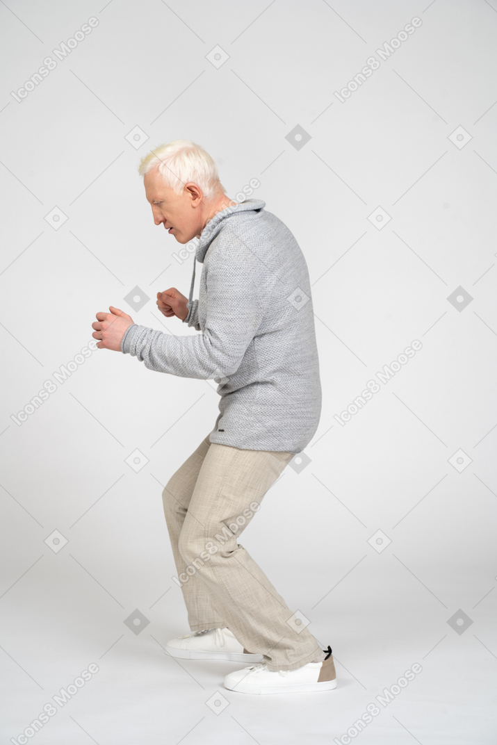 Side view of a man bending knees and clenching fists