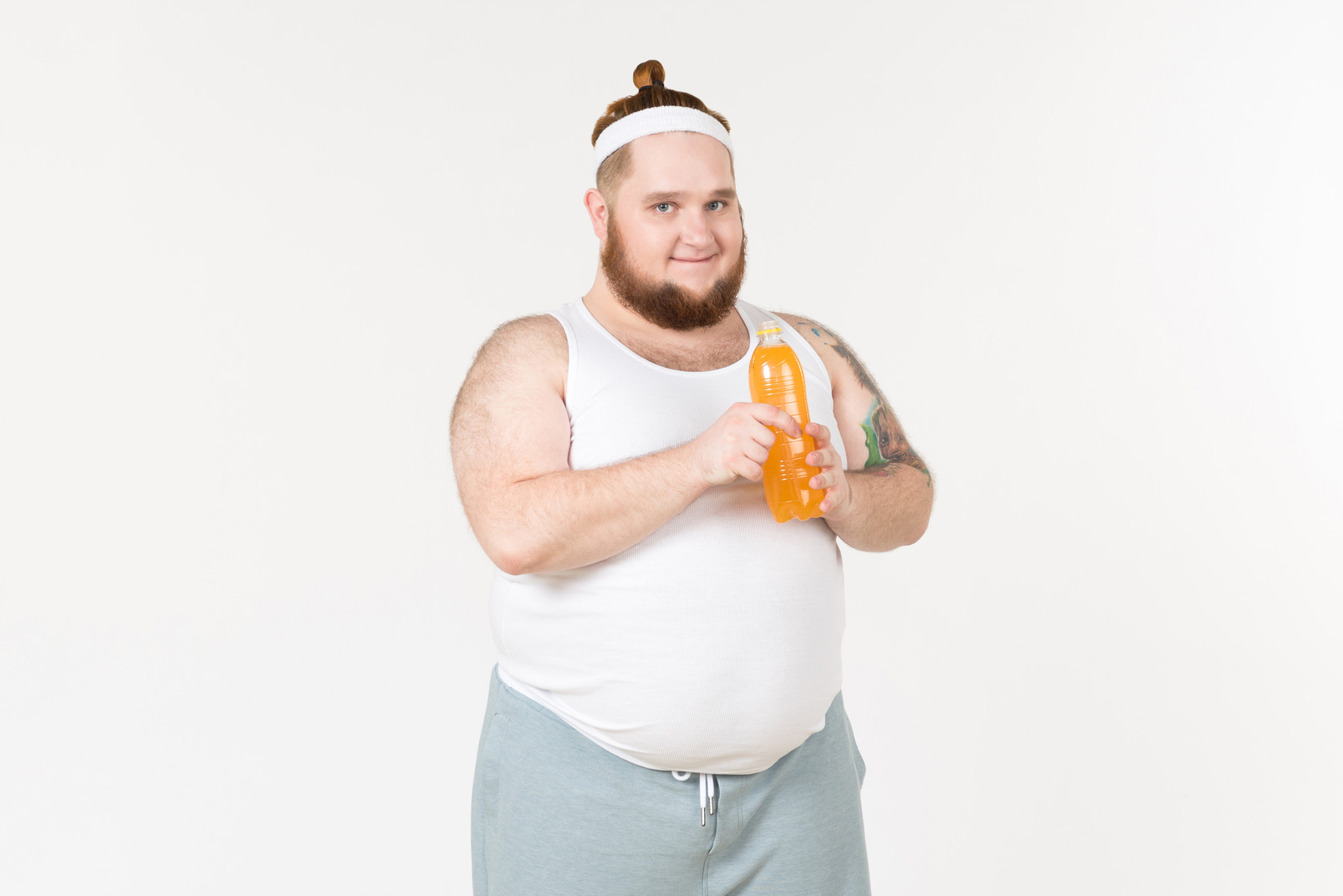 A fat man in sportswear holding a bottle of orange drink