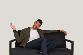 Smiling young man sitting on the sofa