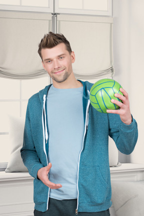A man holding a green ball in his hand