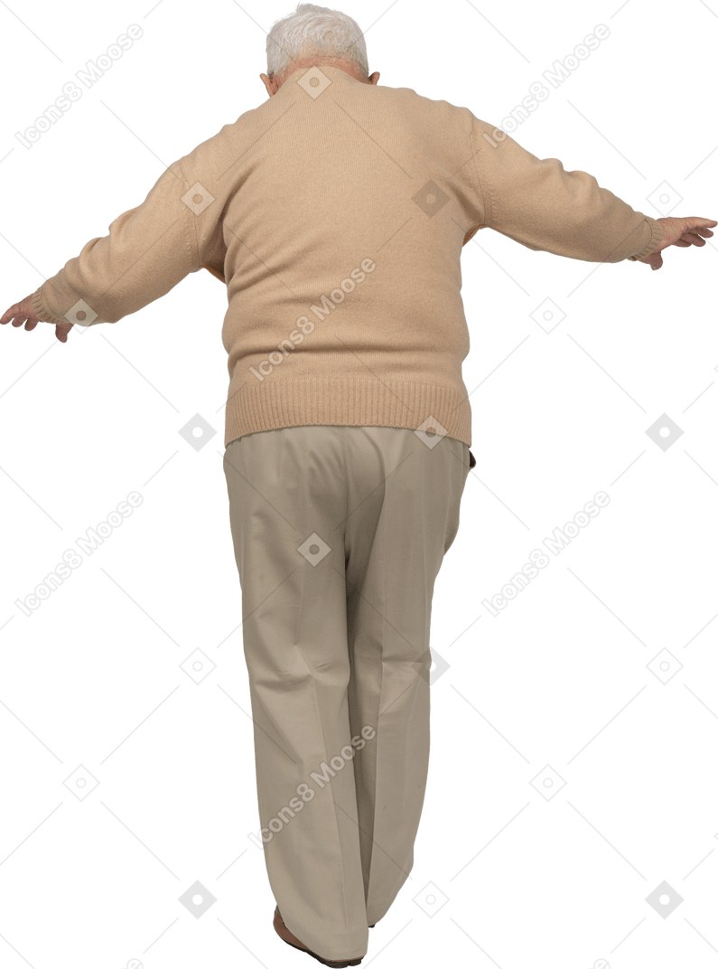 Rear view of an old man in casual clothes walking with outstretched arms