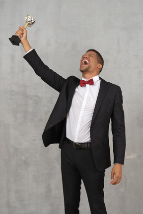 Man holding up award in celebration of his win