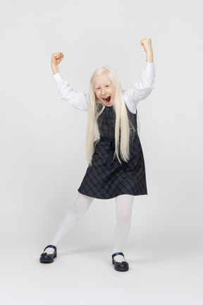 Schoolgirl holding hands up and cheering excitedly