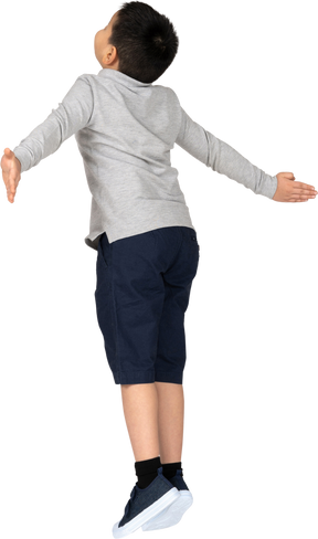 Boy jumping with spread arms