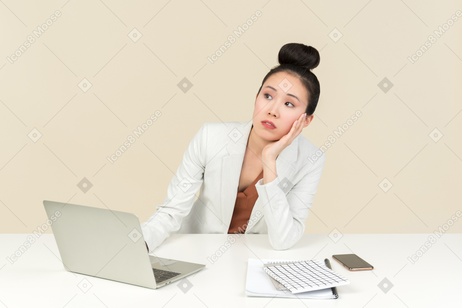 Dreamy young asian female office worker sitting at the desk