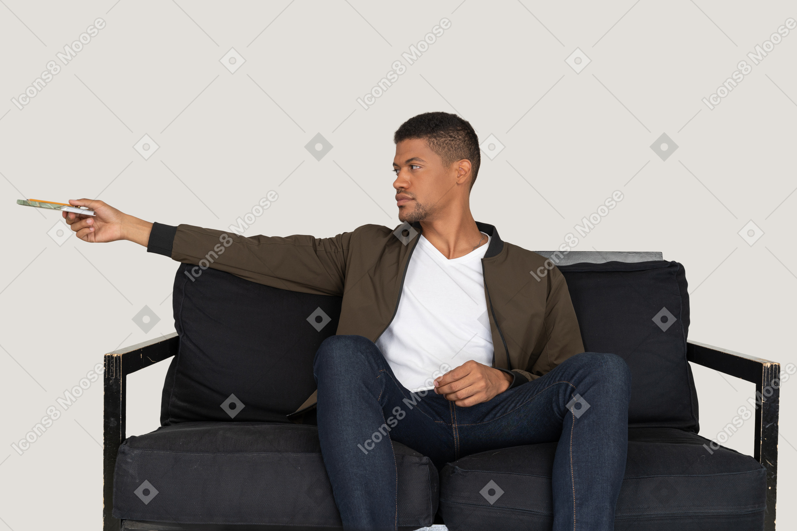 Вид спереди молодого человека, сидящего на диване и проходящего мимо ручки с блокнотом