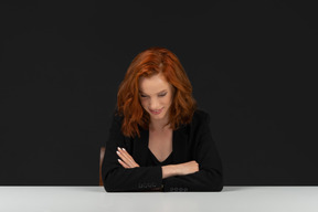 A frontal view of the beautiful girl sitting at the table and smiling