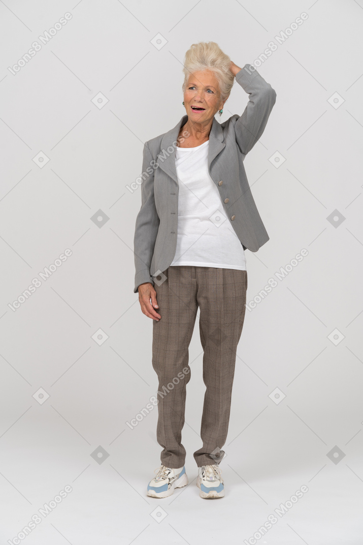 Front view of an old lady in suit touching her hair