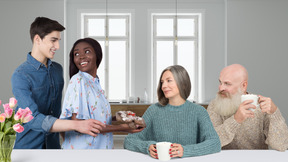 Young couple standing next to elderly couple sitting at table