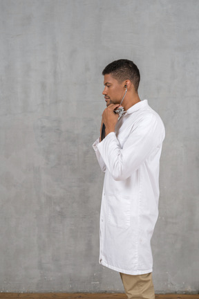 Side view of a male doctor using a stethoscope