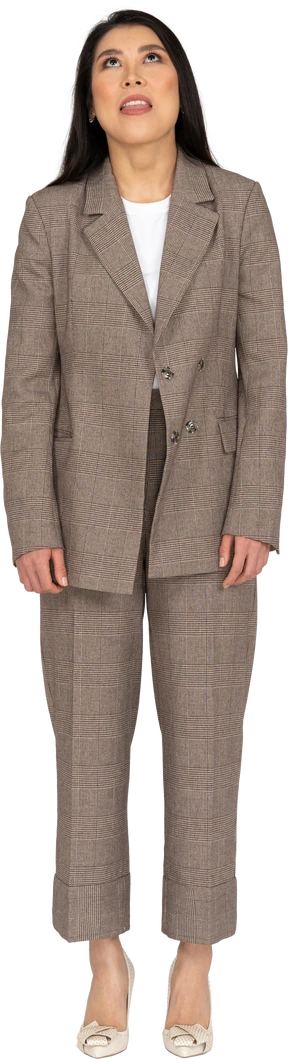Front view of a bored young lady in brown business suit looking up