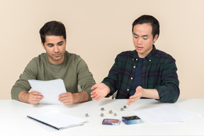 Interracial friends sitting at the table and playing board game