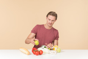 Young guy putting fruits and vegetables into a string bag