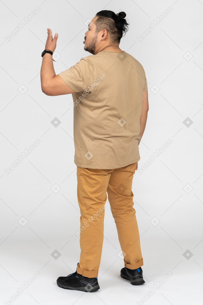 Young asian man gesturing back to camera