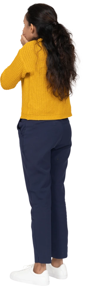 Rear view of a girl in casual clothes covering mouth with hands