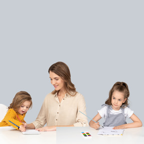 A woman sitting at a desk with two children