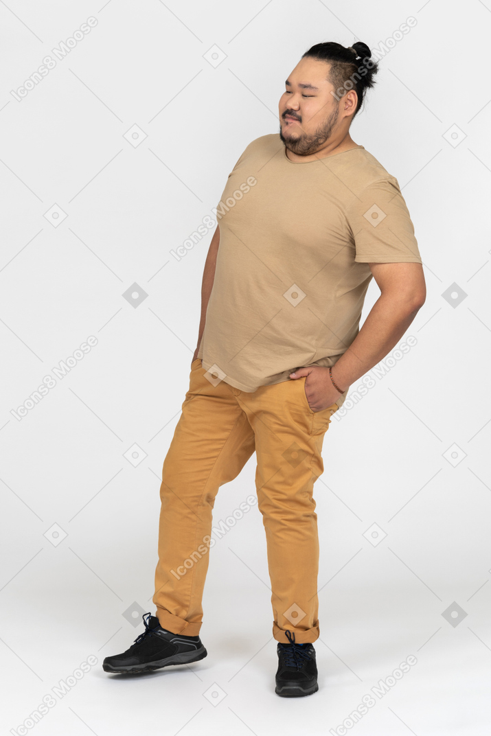 Thoughtful asian man holding hands in pockets