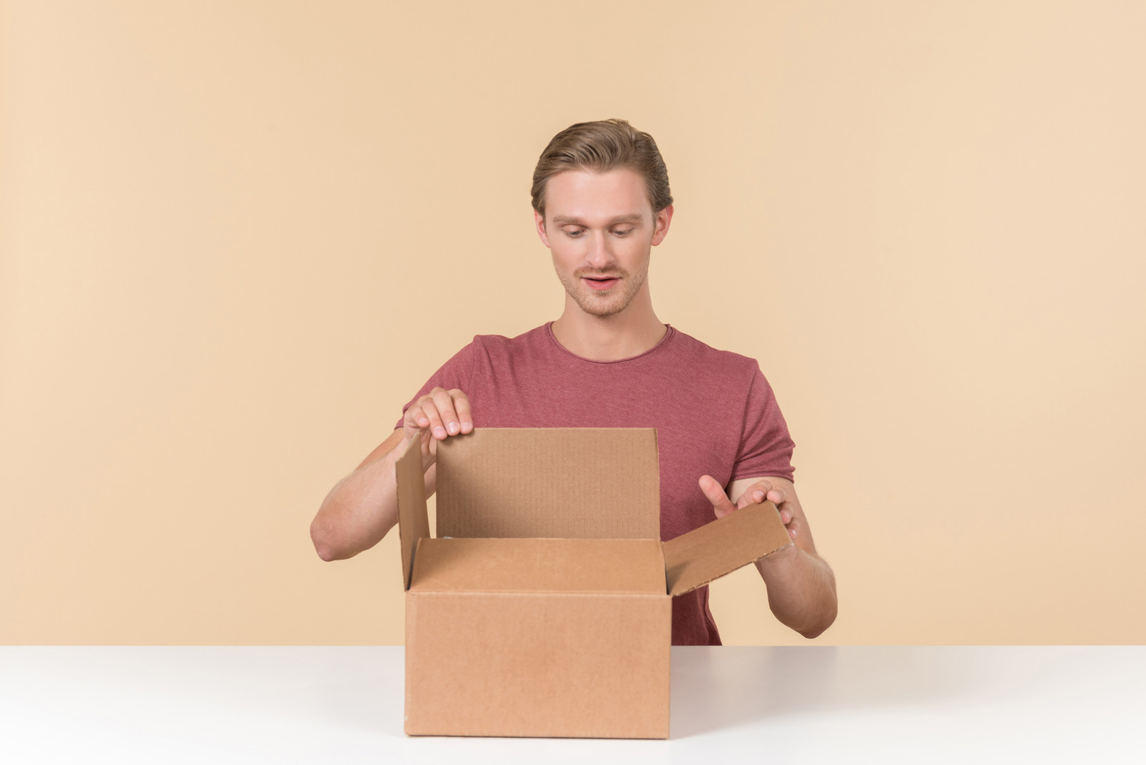 Young guy opening a parcel