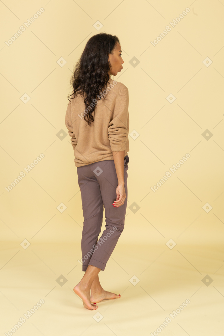 Vista posteriore di una giovane donna in abiti casual a piedi