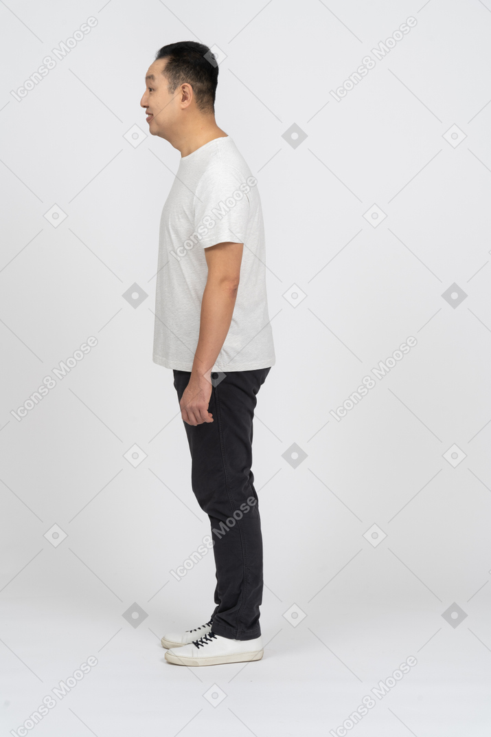 Homem feliz em roupas casuais em pé no perfil