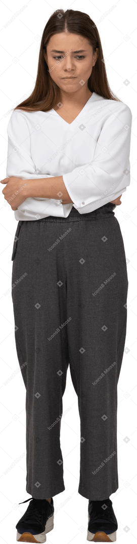 Front view of an upset young lady in office clothing putting hands on belly