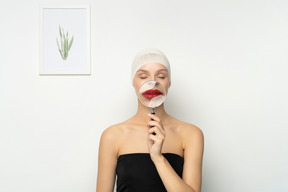 Young woman holding magnifier over her mouth