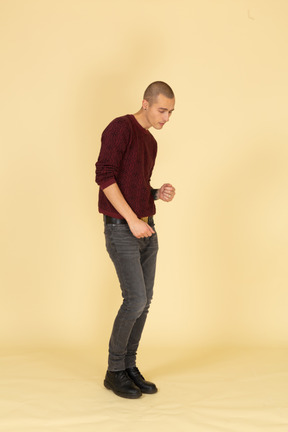 Three-quarter view of a tired dancing young man in red pullover