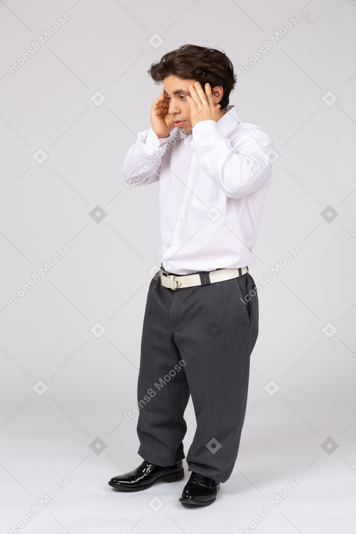 Side view of man with hands on head feeling headache