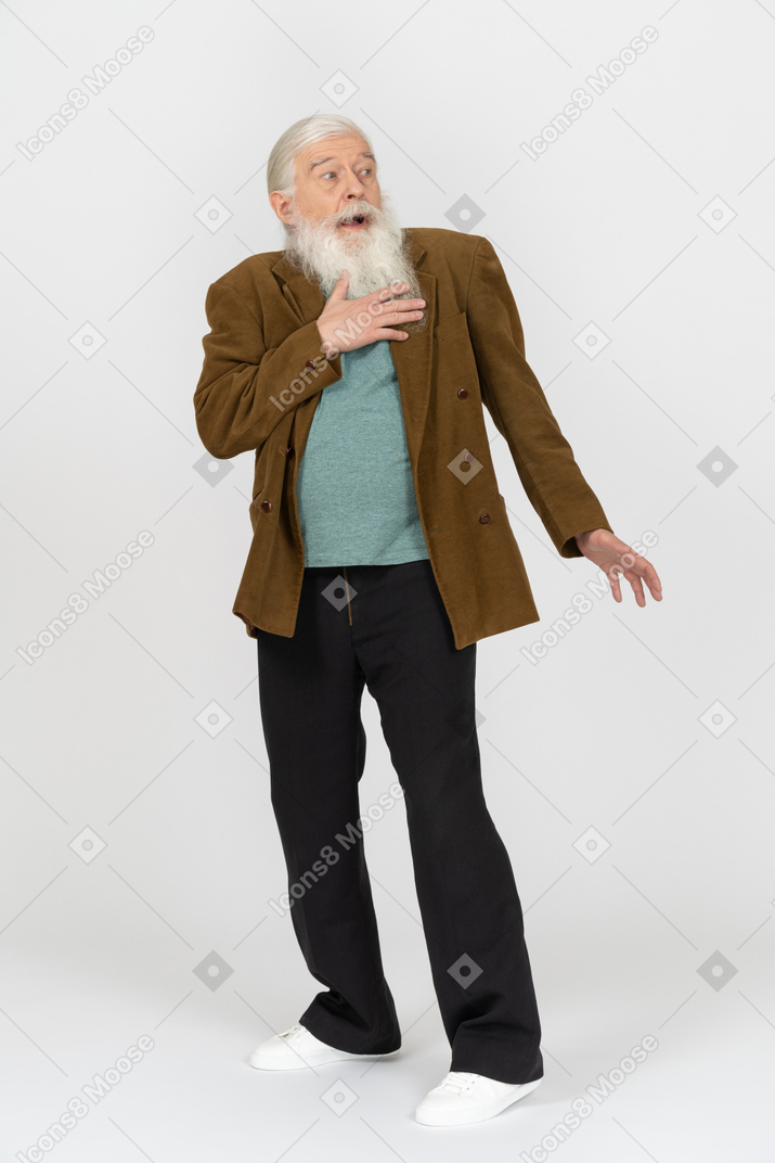Portrait of an old man pressing hand to chest in extreme shock