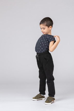 Vista lateral de um menino com roupas casuais, alongamento com as mãos nos ombros