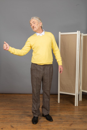 Vista frontal de un anciano mostrando un pulgar hacia arriba