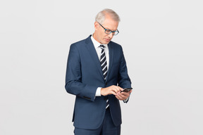 Elegant middle-aged man using his smartphone