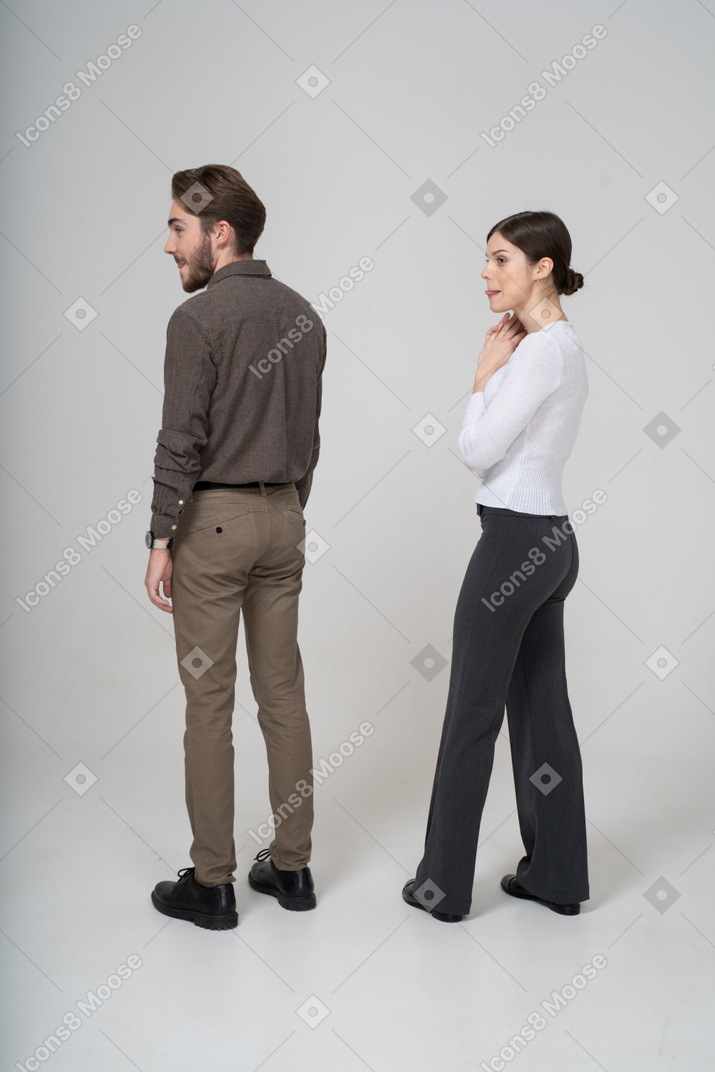 Three-quarter back view of a young couple in office clothing licking lips