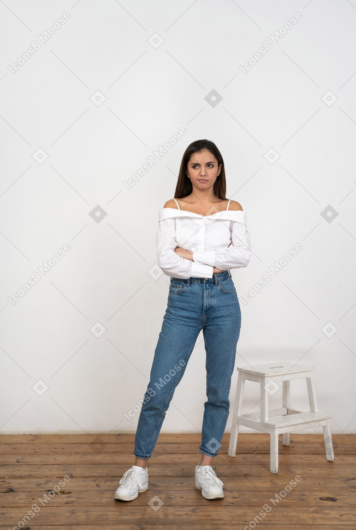 Sceptical young woman standing in room