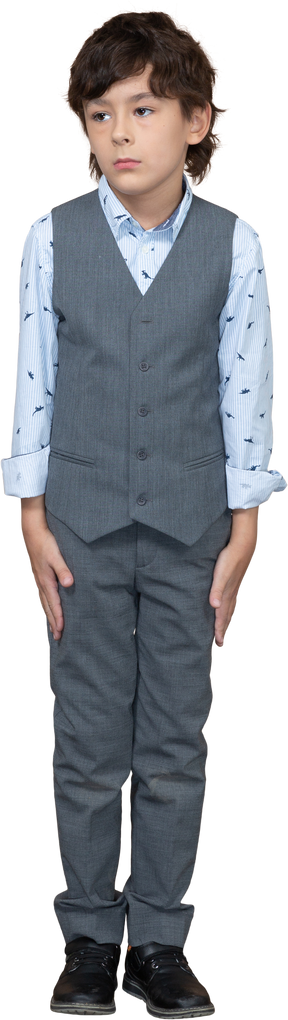 Vista frontal de un niño triste en traje gris parado