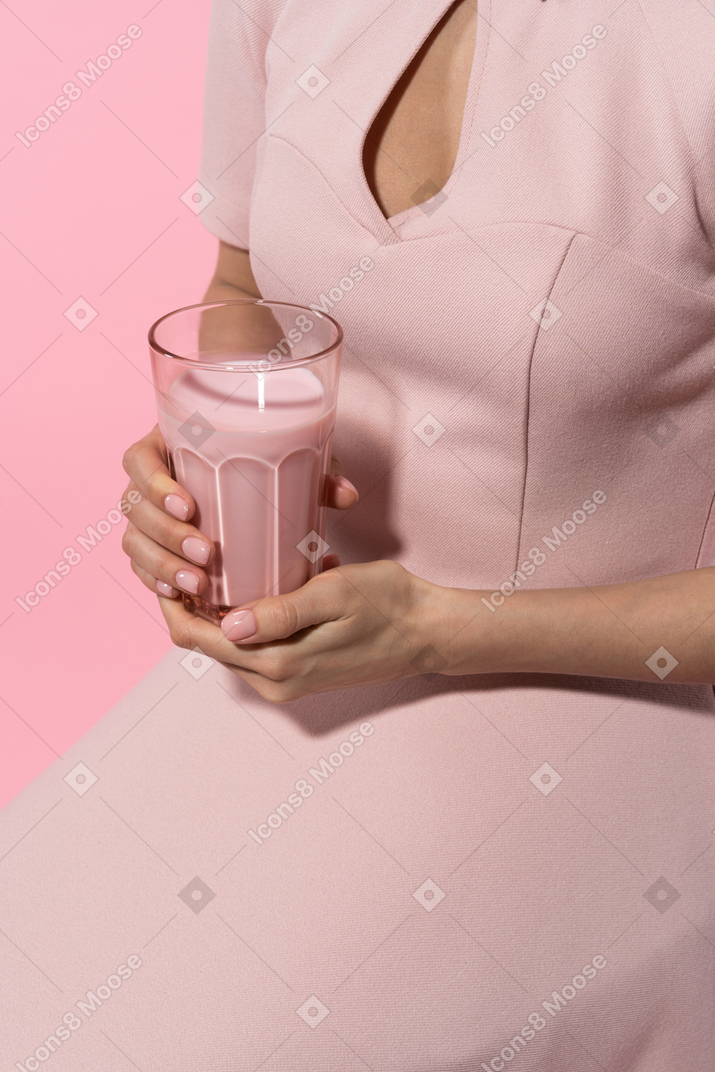 Holding a glass of  yogurt with both hands