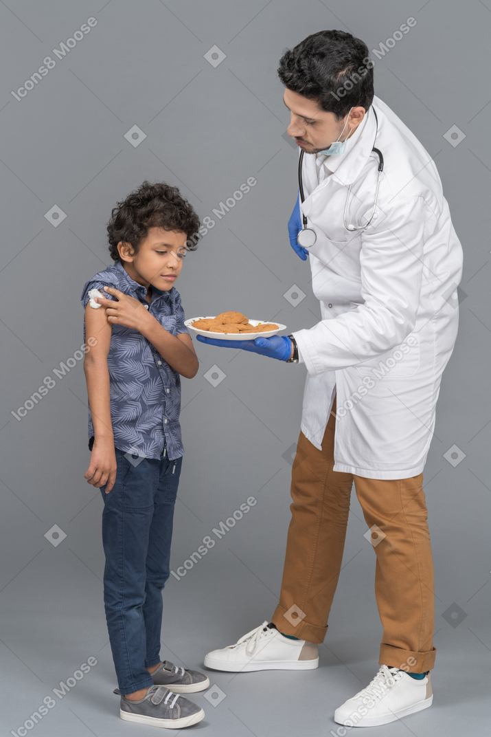 Doctor dando galletas al niño