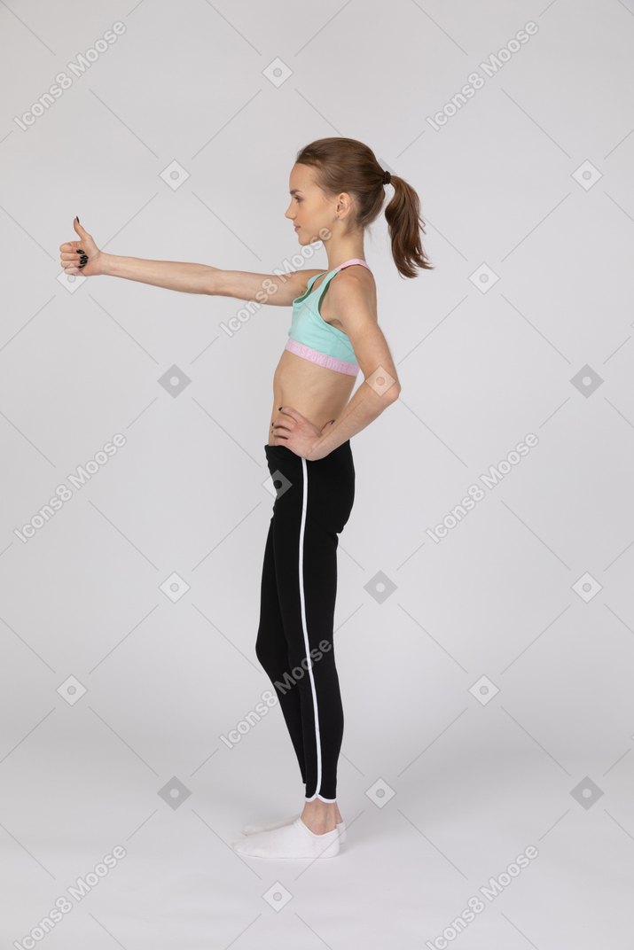 Side view of teen girl showing thumb up