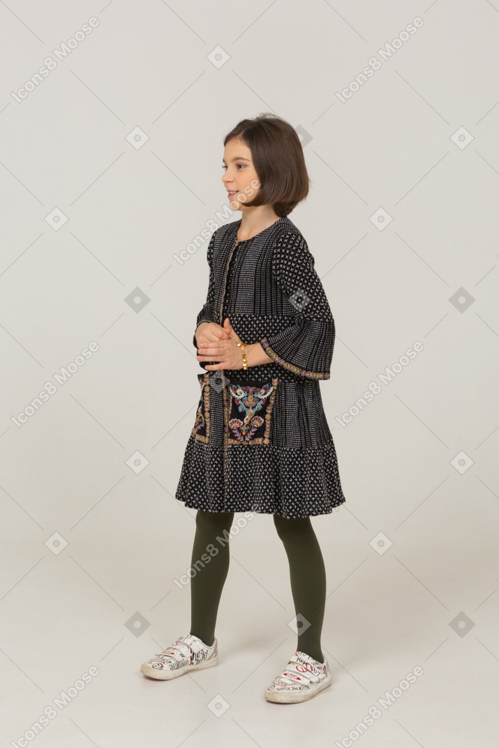Three-quarter view of a gesticulating little girl in dress