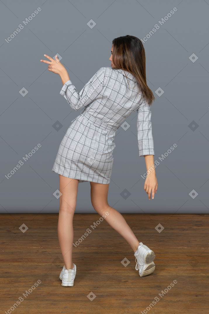 Unrecognizable young woman dancing back to camera
