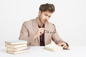 Guapo joven leyendo libros