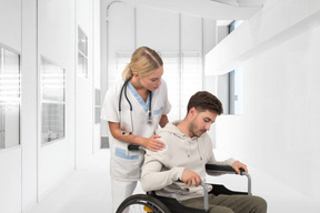 A man in a wheelchair being assisted by a nurse