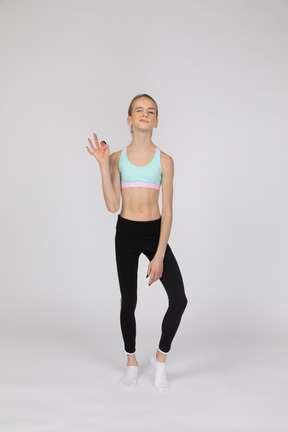 Side view of a teen girl in sportswear raising hand and arguing