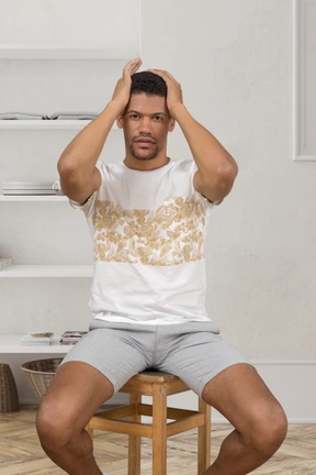 Hombre cansado sentado con las manos en la cabeza