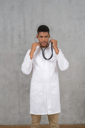 Médecin de sexe masculin à l'aide de son stéthoscope