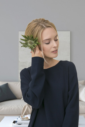 A woman is holding a plant in her hand