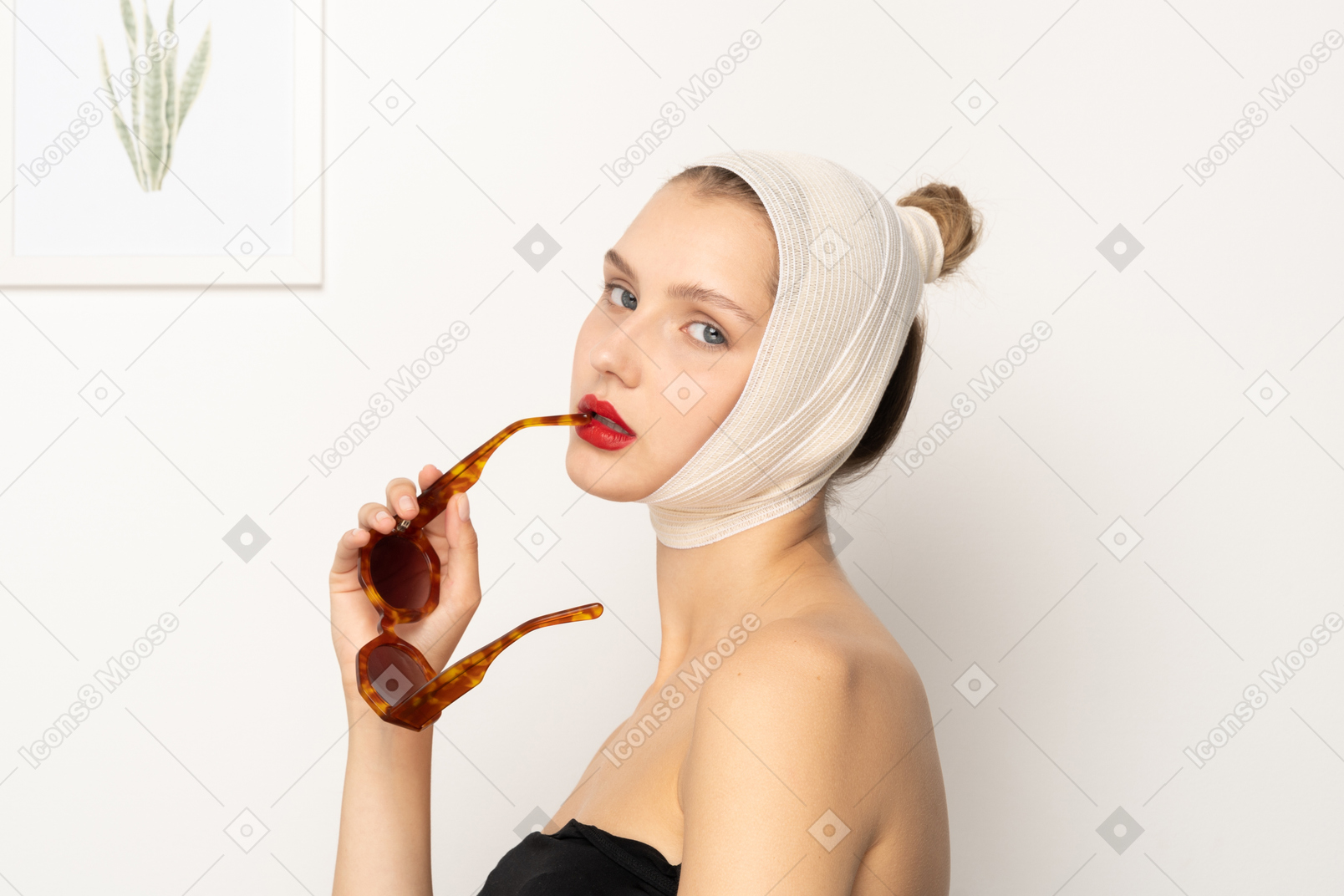 サングラスを保持している包帯の頭を持つ若い女性