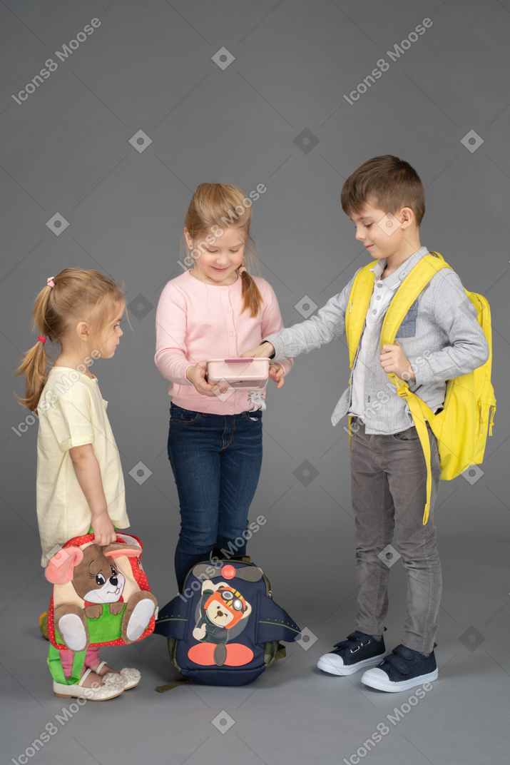Joyeuse petite fille partageant des jouets avec des amis
